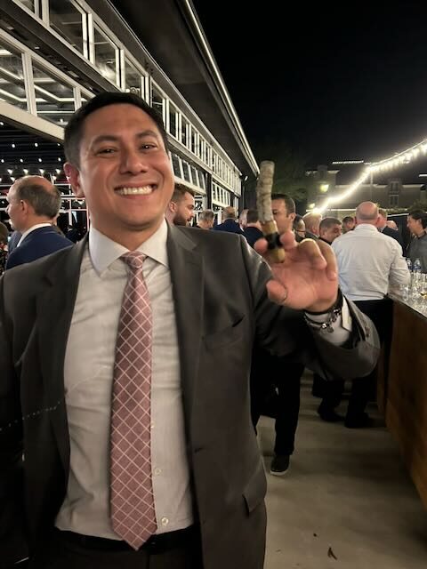 A guest enjoying one of Joe's cigars at an evening event