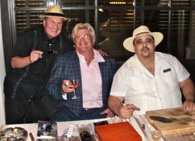Joe and a guest with a cigar sponsor sign at Elaine's table