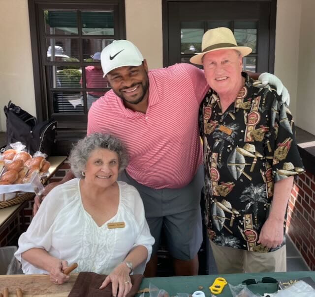 Joe and Elaine with a golfer holding hand-rolled cigars