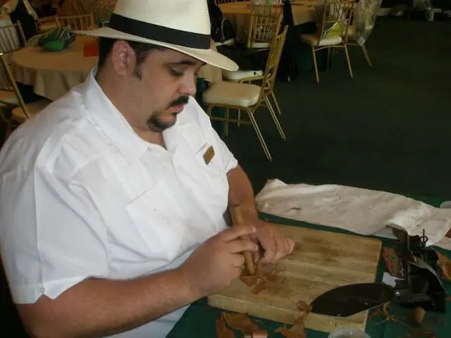 112dde8c-f16e-36e6-31c7-1d49e814ae5c A man in white shirt and hat holding a knife.