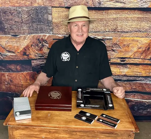 664dc6bf-7015-5eb7-7e82-12123b9d7412 A man sitting at a table with some items on it
