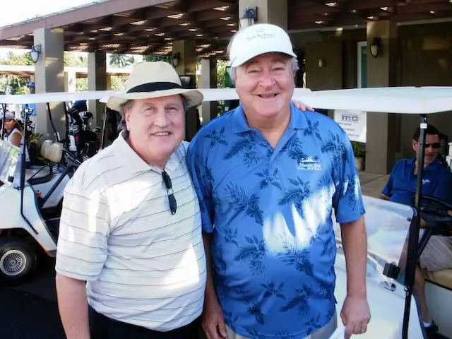 9bf6079f-6755-9445-bb6e-ff36eb4fcfd7 Two men standing next to each other in a golf course.