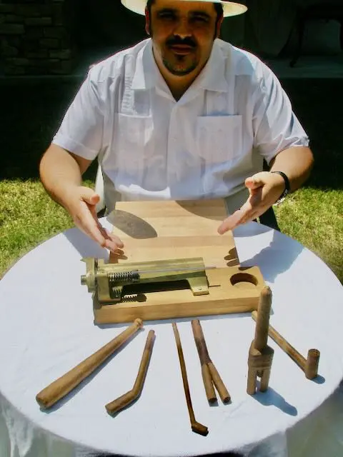 ad87bf77-fa2d-e8fe-ae66-3b8158f1ae94 A man is working on an object with wooden sticks.